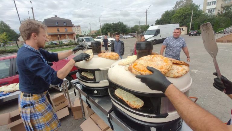 Фото 1 до: Іноземні волонтери годують піцою переселенців