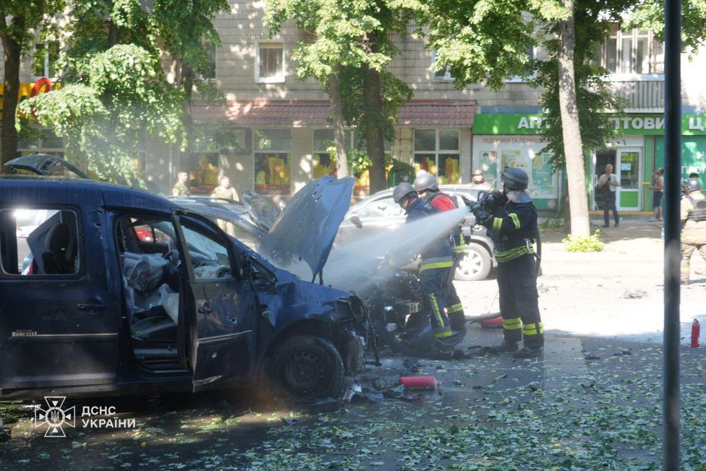 Рятувальники гасять вогонь в автомобілях, які потрапили під обстріл у Сумах.